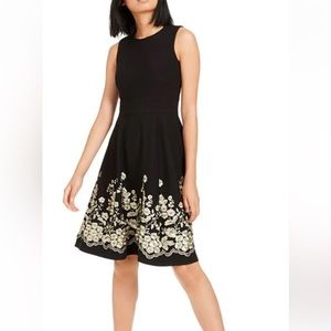 Calvin Klein black sleeveless a line dress with gold tone embroidery flower.
